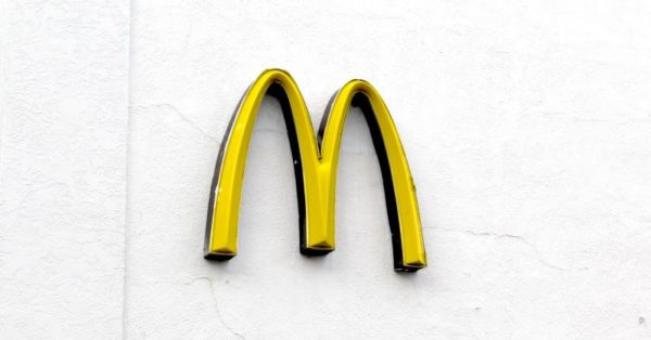 McDonalds yellow arches sign on the side of white stucco building