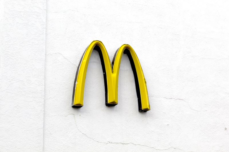 McDonalds yellow arches sign on the side of white stucco building
