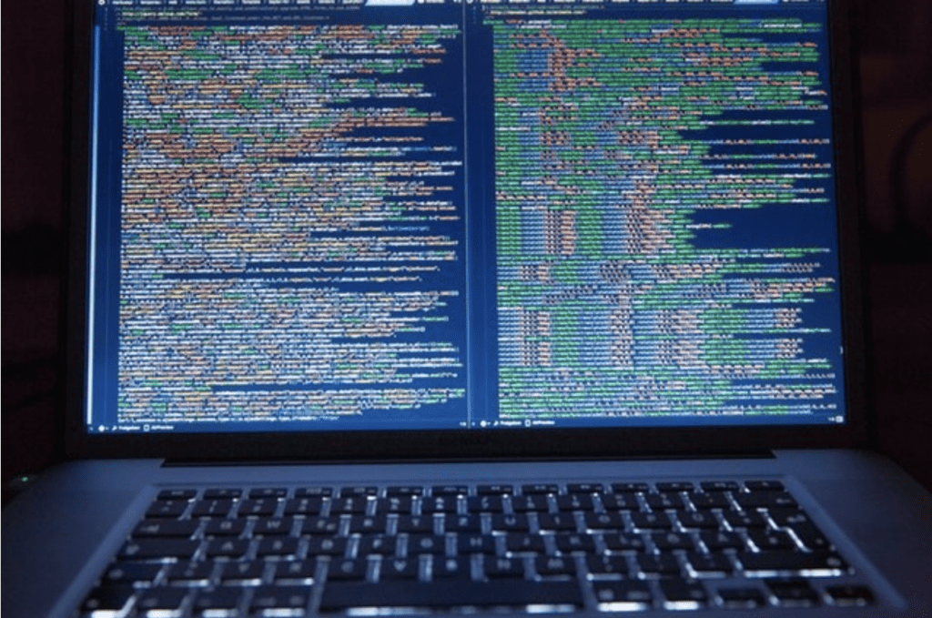 Laptop opened displaying lines of code on the screen